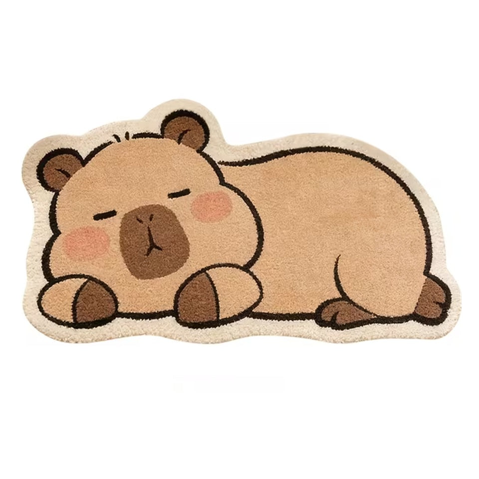 Gros plan sur un tapis de sol en forme et aux couleurs d'un adorable capybara. Il est couché et semble dormir paisiblement. Idéal pour décorer une chambre, une salle de jeu, un coin lecture etc...