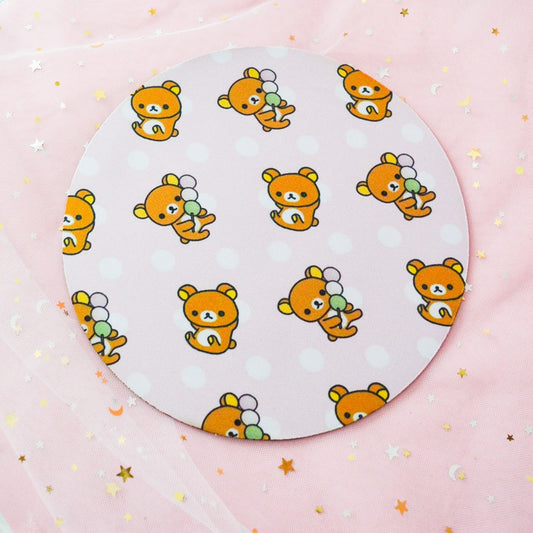 un tapis de souris rond au motif de rilakkuma dégustant de délicieux dango. Couleurs vives et pastels.