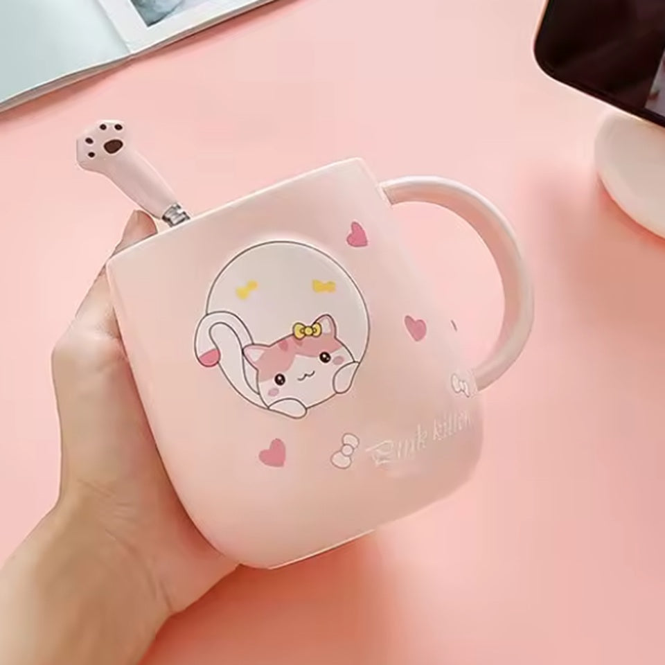une jolie tasse rose au design d'un adorable chat. La tasse possède un couvercle doté d'un poisson et d'une cuillère en forme de patte de chat. Le couvercle sert également de support pour smartphone. Vous pouvez y mettre votre smartphone pour regarder une série pendant que vous savourez un café.