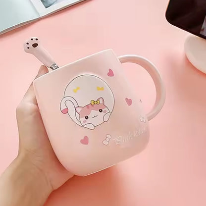 une jolie tasse rose au design d'un adorable chat. La tasse possède un couvercle doté d'un poisson et d'une cuillère en forme de patte de chat. Le couvercle sert également de support pour smartphone. Vous pouvez y mettre votre smartphone pour regarder une série pendant que vous savourez un café.