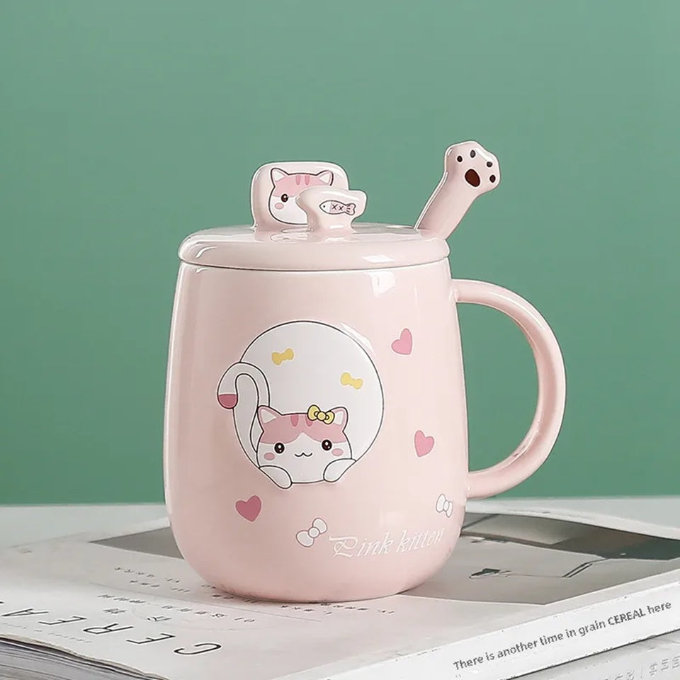 une jolie tasse rose au design d'un adorable chat. La tasse possède un couvercle doté d'un poisson et d'une cuillère en forme de patte de chat. Le couvercle sert également de support pour smartphone. Vous pouvez y mettre votre smartphone pour regarder une série pendant que vous savourez un café.
