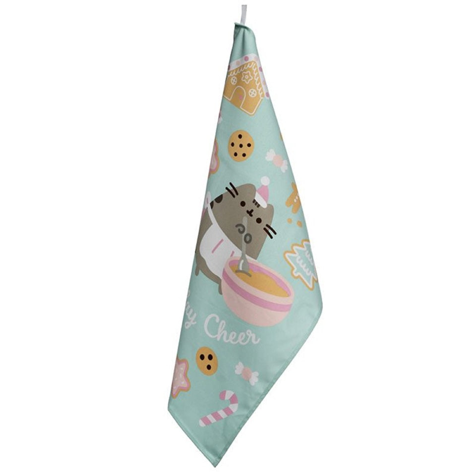 un torchon en coton au motif de Pusheen hyper mignon et coloré. Sur le thème de Noël, il y a des cookies, des sapins, des bonhommes en pain d'épices typiques de la saison hivernale.