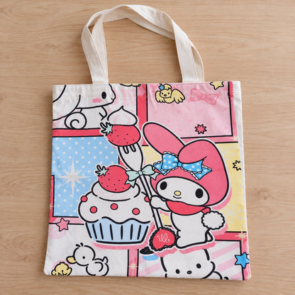 Sac tote bag My Melody kawaii aux couleurs pastel, décoré de fraises, cupcake et motifs adorables, posé à plat sur une table en bois clair.