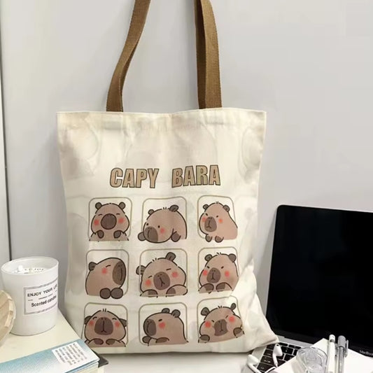 un joli tote bag inspiré des capybara. Illustré de plusieurs cases dans lesquelles se trouve un capybara différent à chaque fois, il est adorable ! En polyester, il est résistant et durable.