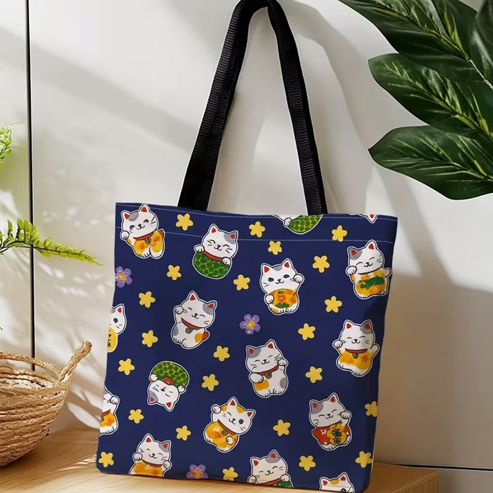 un adorable tote bag bleu illustré de maneki neko trop mignons et d'étoiles jaunes.
