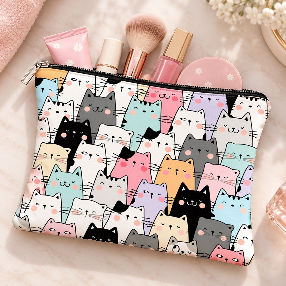 Trousse de toilette kawaii à motifs de chats multicolores pastel, posée à plat et entrouverte avec pinceau de maquillage, rouge à lèvres et produits cosmétiques. Pochette zippée mignonne et pratique, idéale pour ranger maquillage, accessoires de beauté et essentiels du quotidien.