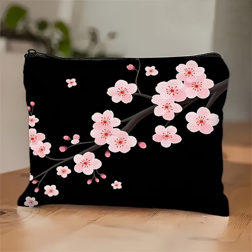 une jolie trousse de toilette noire au motif de fleurs de sakura rose posée sur une table en chêne dans un décor simple et zen.