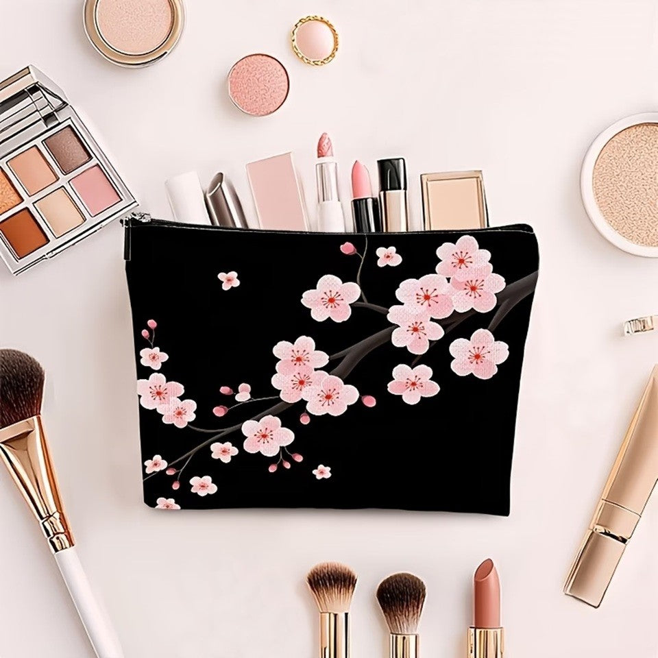 une jolie trousse de toilette noire au motif de fleurs de sakura rose posée sur une table blanche. Elle contient des produits de beauté qui dépassent légèrement. Tout autour, se trouvent des articles divers de produits de beauté.