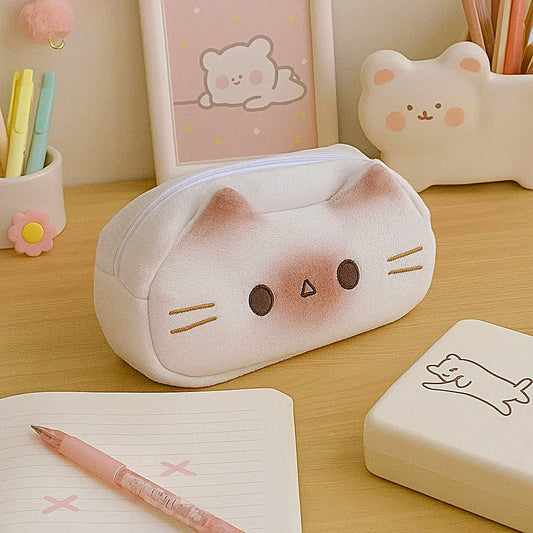 une superbe trousse toute douce et tout en peluche en forme de chat siamois hyper mignon. Elle a des petites oreilles trop mignonnes et une expression kawaii