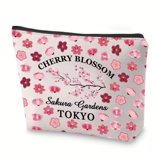 une magnifique trousse de toilette en polyester ornée de motifs de fleurs de sakura roses. Le motif rappelle les sakura en fleurs dans les jardins de Tokyo.