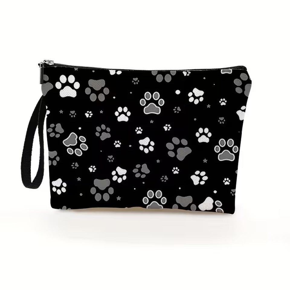 une trousse de toilette noire au motif de pattes de chat blanches et grises. Design hyper mignon et tissu doux. Idéale pour le quotidien et les vacances.