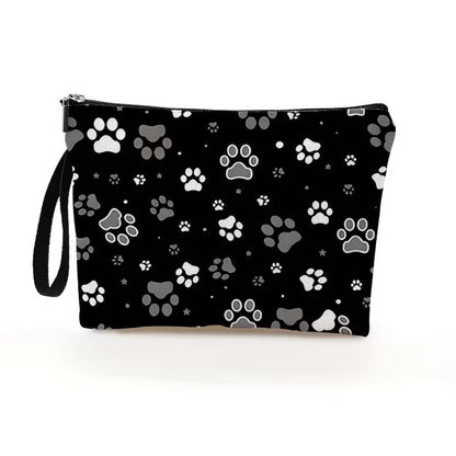 une trousse de toilette noire au motif de pattes de chat blanches et grises. Design hyper mignon et tissu doux. Idéale pour le quotidien et les vacances.