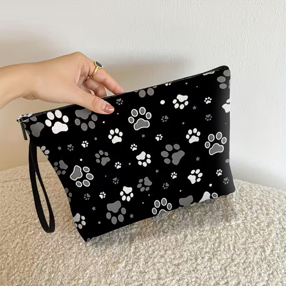 une trousse de toilette noire au motif de pattes de chat blanches et grises. Design hyper mignon et tissu doux. Idéale pour le quotidien et les vacances.
