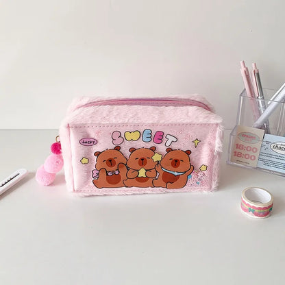 une adorable trousse capybara toute fluffy, aux couleurs pastels. Une illustration de capybara tout mignon renferme des paillettes colorées. C'est un vrai câlin rempli de douceur.