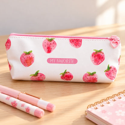 Trousse scolaire kawaii blanche à motif de fraises roses façon aquarelle, avec fermeture éclair rose et inscription « MY FAVORITE ». Présentée sur un bureau en bois clair avec stylos pastel et carnet fleuri, idéale pour ranger crayons, maquillage et petits accessoires.