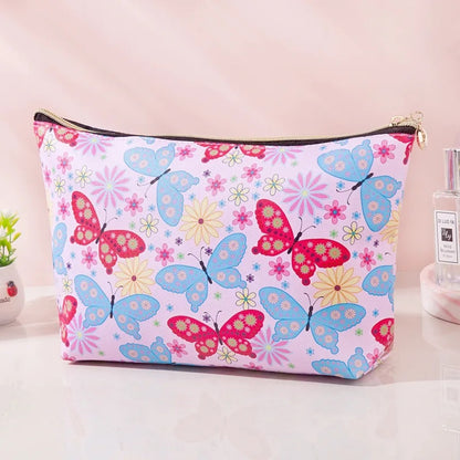 une trousse de toilette en simili cuir illustrée de papillons colorés et de fleurs multicolores. Look printanier et coloré.