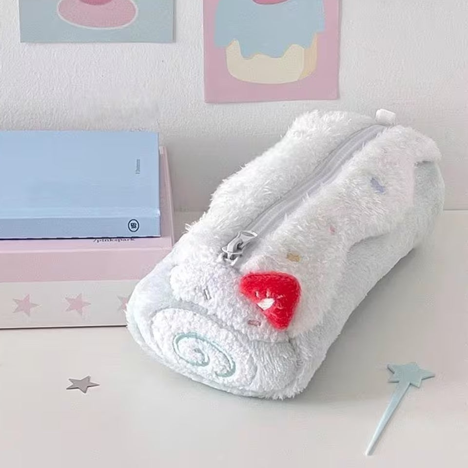 Une trousse en peluche kawaii bleu pastel  posée sur une bureau blanc, entouré de fournitures de papeterie diverses. Ambiance mignonne et calme