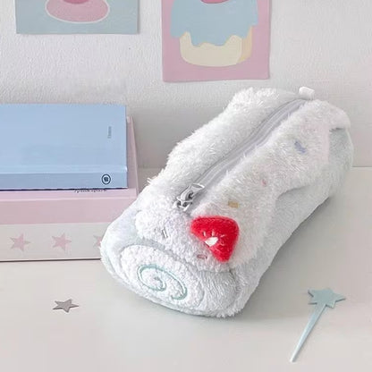 Une trousse en peluche kawaii bleu pastel  posée sur une bureau blanc, entouré de fournitures de papeterie diverses. Ambiance mignonne et calme
