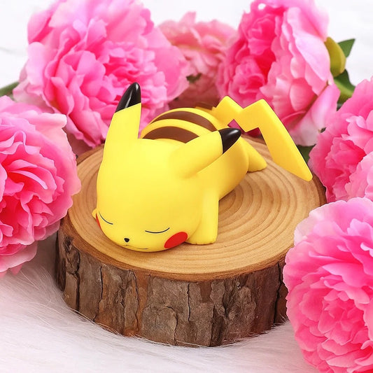 une veilleuse en forme pikachu hyper mignonne et adorable. Il dort tranquillement sur le ventre. Sa douce lumière se diffuse tendrement.