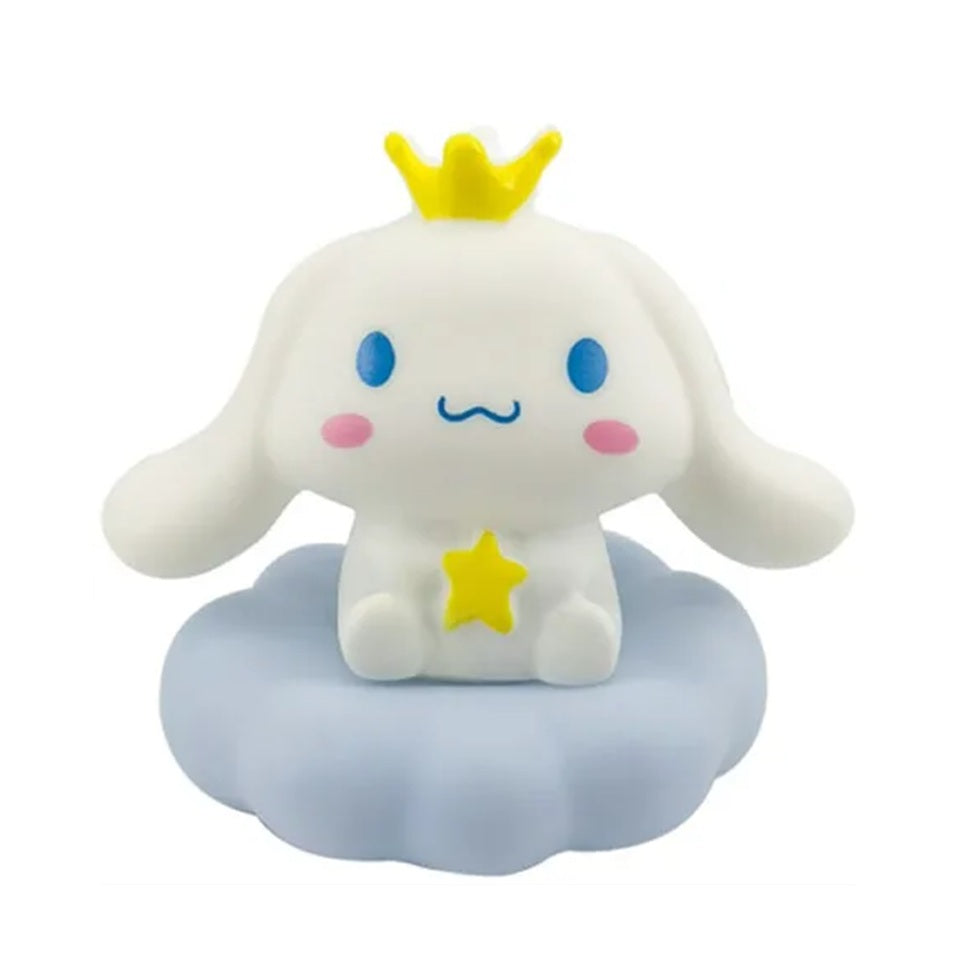 une adorable veilleuse cinnamoroll qui tient une étoile dans ses mains et qui porte une couronne jaune sur la tête. Il est assis sur un petit nuage. C'est une scène tendre. Elle diffuse de la lumière douce pour créer un effet cocooning.