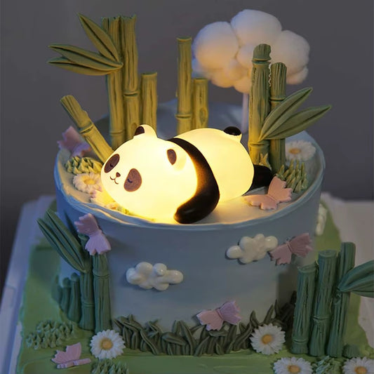 une adorable veilleuse en plastique en forme d'un petit panda allongé sur le ventre avec une expression endormie. Elle diffuse une douce lumière jaune réconfortante et calme.