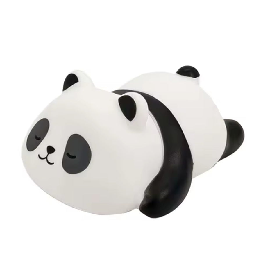 une adorable veilleuse en plastique en forme d'un petit panda allongé sur le ventre avec une expression endormie. Elle diffuse une douce lumière jaune réconfortante et calme.