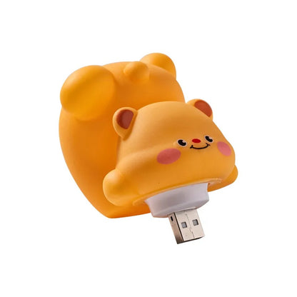 Gros plan sur une adorable veilleuse en forme d'ourson qui fait une galipette. Elle possède une prise USB.